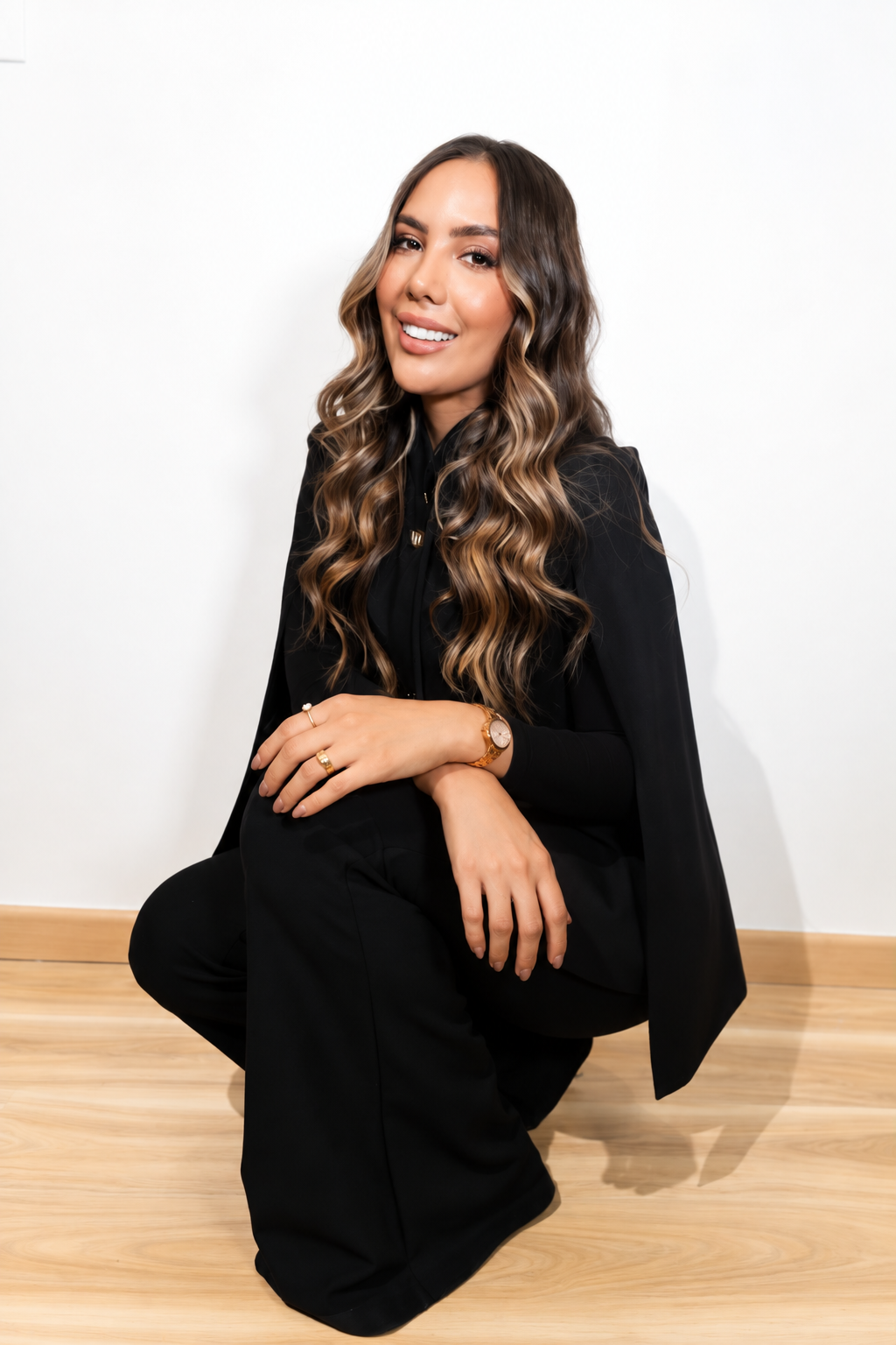 Laura Castañeda sonriendo, vestida de negro sobre fondo blanco